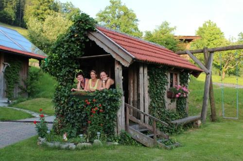 three women are sitting in a play house at Gesundheitshof Lohninger in Mondsee