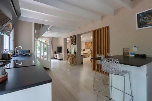 a kitchen and living room with a counter and chairs at la villa in Lacanau