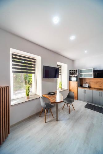 Una cocina con una mesa y sillas en una habitación. en Apartament pod Zamkiem Książ "Nowa Szwajcarka", en Świebodzice