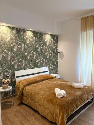 a bedroom with a large bed with a tropical wallpaper at MVM Apartment in Rome