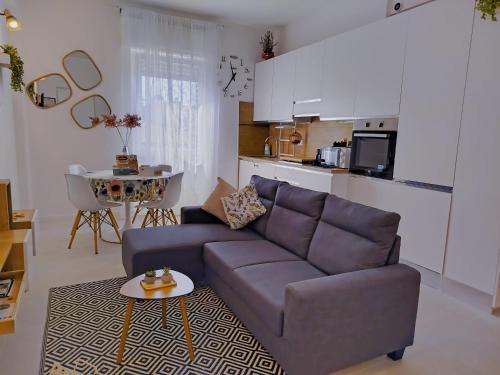 a living room with a couch and a kitchen at Verona Bed and Relax Apartment in Verona