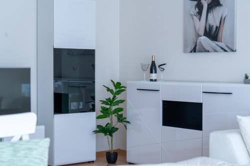 a living room with white furniture and a plant at Evgeny's Stylishly Designed 2 Bedroom Apartment plus Garage! in Sofia