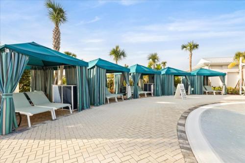 eine Terrasse mit blauen Sonnenschirmen und einem Swimmingpool in der Unterkunft 5 Bedrooms 5 Bathrooms Windsor Cay 16202Cc in Clermont