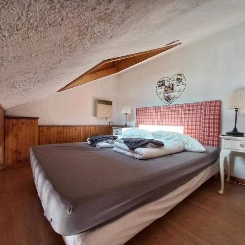 a bedroom with a large bed with a red headboard at 13 Lou Veno in Les Deux Alpes