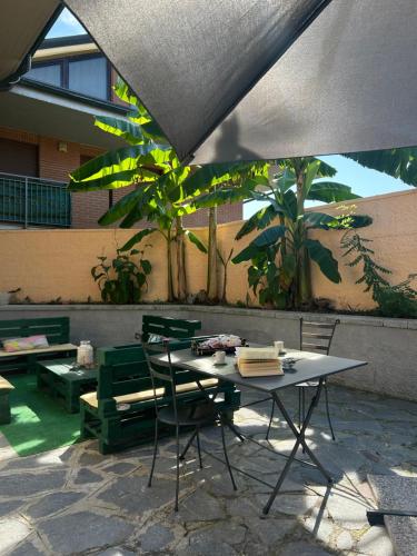a table and chairs in a patio with a table and benches at Villa Luce in Vairano
