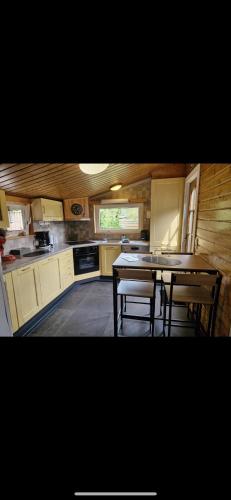 a kitchen with a table and chairs in it at La tanière du ptit Lou in Resteigne
