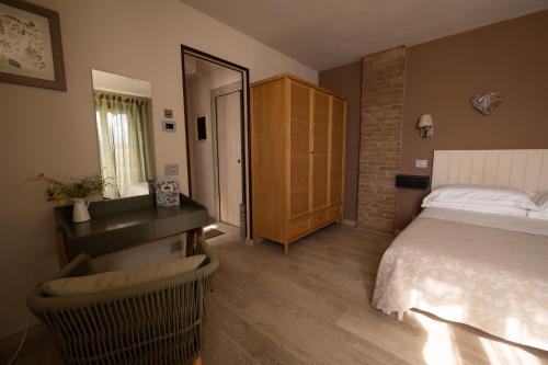 a bedroom with a bed and a dresser and a mirror at Poggio dei Farinetti in Diano dʼAlba