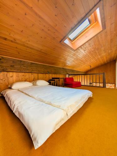 a large bed in a room with a skylight at Cœur de Champéry, terrasse & près des remontées ! in Champéry