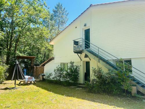a white house with a porch and a balcony at la villa in Lacanau