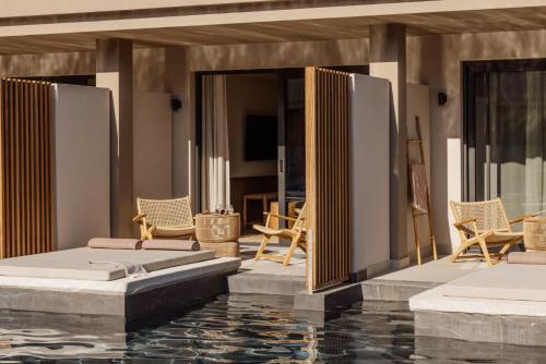 a house with a swimming pool with chairs and a house at Unda in Litherés