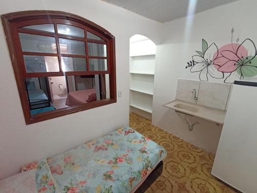 a small room with a bed and a window at Refúgio de Piratininga 204 in Niterói