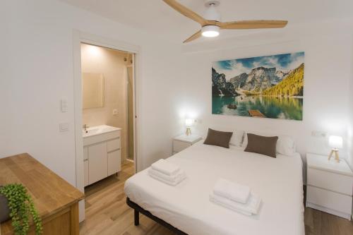 ein Schlafzimmer mit einem weißen Bett und ein Badezimmer in der Unterkunft The Alou Apartment 2 - Montiboli - Private Beach in Villajoyosa