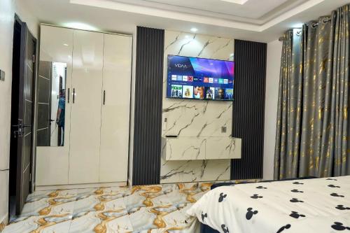 a bedroom with a king sized bed and a television at Tenacity in Lekki