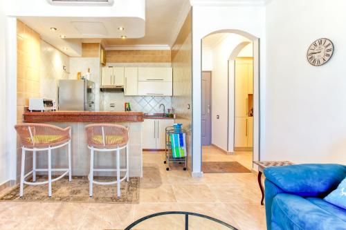 a kitchen and a living room with a blue couch at One bedroom apartment A 401 by Peaks Palm Beach Piazza Sahl Hasheesh in Banī Ghālib