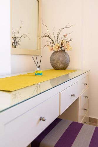 a dresser with a vase on top of it at One bedroom apartment A 401 by Peaks Palm Beach Piazza Sahl Hasheesh in Banī Ghālib