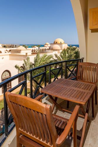 a table and chairs on a balcony with a view of the ocean at One bedroom apartment A 401 by Peaks Palm Beach Piazza Sahl Hasheesh in Banī Ghālib