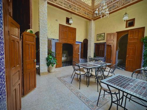 a room with tables and chairs in a building at Riad Shama in Rabat