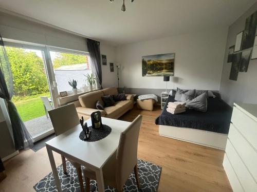 a living room with a couch and a table at Apartment mit Garten in Bad Lauterberg