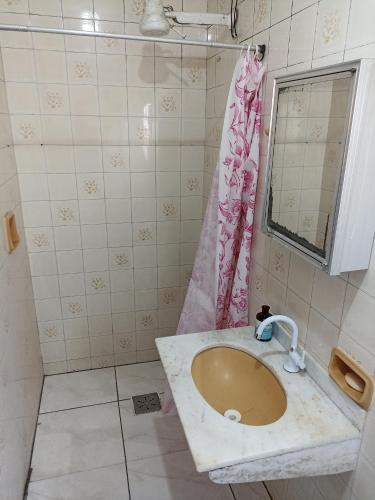 a bathroom with a sink and a pink shower curtain at Refúgio de Piratininga 204 in Niterói