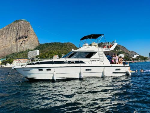 a white boat in the water with people on it at Lancha Oceanic RJ in Rio de Janeiro