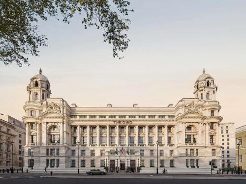 a large white building with a car parked in front at Raffles London at The OWO in London