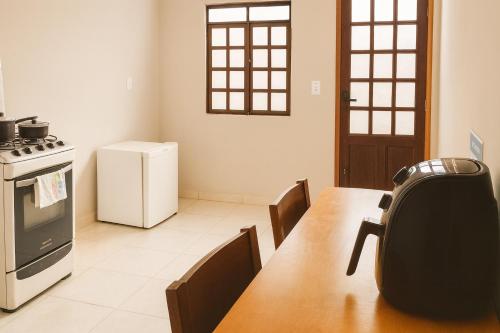a kitchen with a table and a stove and a refrigerator at Maestro in Fortaleza