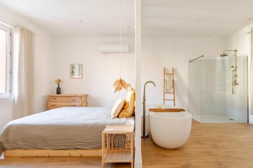 una camera bianca con letto e vasca da bagno di Chaleureuse maison en centre ville a Perpignano