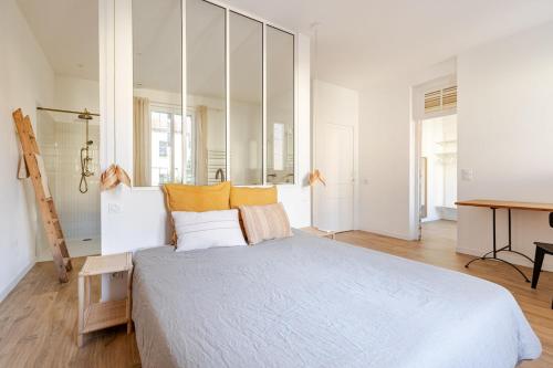 una camera da letto con un letto grande con cuscini gialli di Chaleureuse maison en centre ville a Perpignano