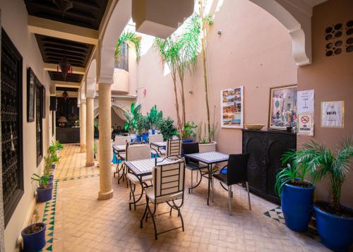 un patio avec tables et chaises dans un bâtiment dans l'établissement Riad Tala, à Marrakech