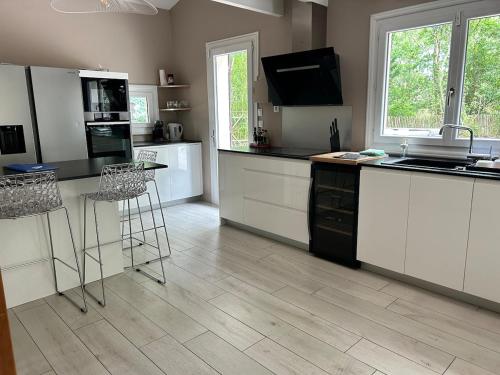 a kitchen with white cabinets and a counter top at Villa haut de gamme 11 personnes jacuzzi privé in Lacanau