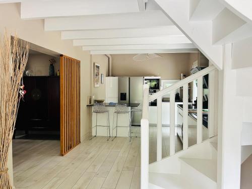 a living room with a staircase and a kitchen at Villa haut de gamme 11 personnes jacuzzi privé in Lacanau