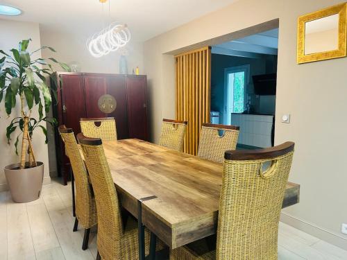 a dining room with a wooden table and chairs at Villa haut de gamme 11 personnes jacuzzi privé in Lacanau