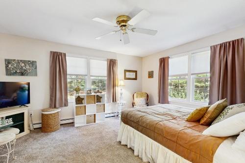 a bedroom with a bed and a tv and windows at White Mountain Getaway in Ossipee