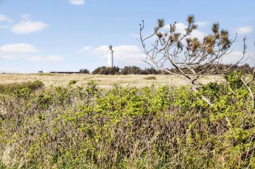 a lighthouse in the middle of a field with a plant at LN1953-Hirtshals-Klinken-26 in Hirtshals