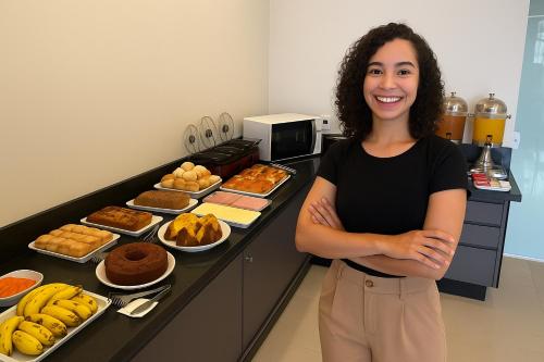 eine Frau steht vor einem Buffet mit Essen in der Unterkunft Dok Brasília Hotel Unidade Águas Claras in Taguatinga