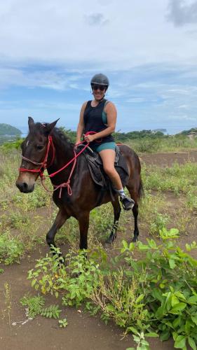 a woman riding a horse in a field at Finca Brisas de la Montaña in Coco