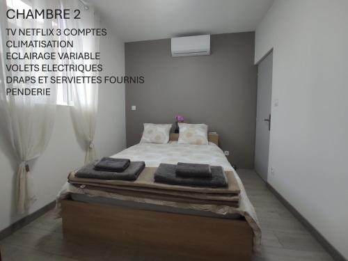 a bedroom with a bed with towels on it at Jolie maison Clermont Saint Jean in Clermont-Ferrand