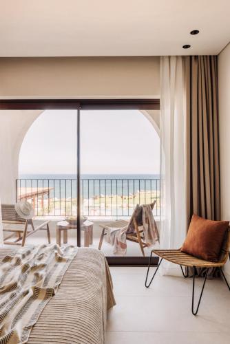 a bedroom with a bed and a view of the ocean at Cabo in Kavos