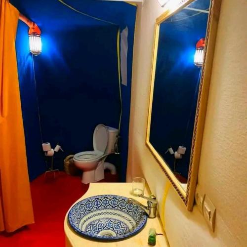 a bathroom with a sink and a toilet and a mirror at Merzouga Desert Tents in Merzouga