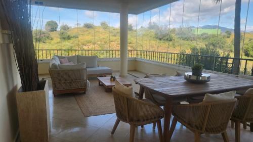 ein Wohnzimmer mit einem Tisch und Stühlen auf dem Balkon in der Unterkunft Casa Ines in Mijas Costa