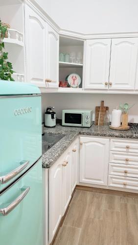 a kitchen with white cabinets and a blue refrigerator at Abades South Beach Domi,air,wifi ,parking in Abades