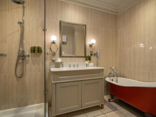 a bathroom with a tub and a sink and a bath tub at Lough Erne Resort in Enniskillen