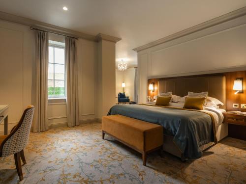 a large bedroom with a large bed and a desk at Lough Erne Resort in Enniskillen