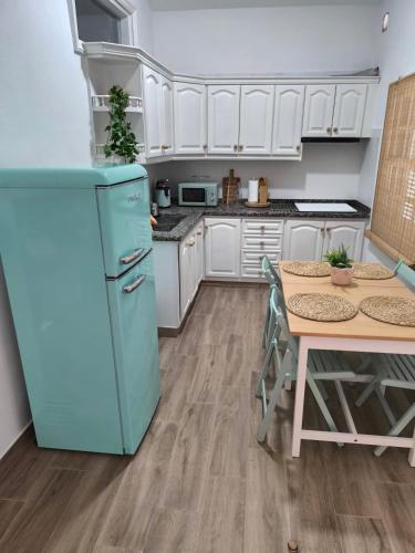 a kitchen with a blue refrigerator and a table at Abades South Beach Domi,air,wifi ,parking in Abades