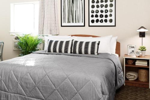 a bedroom with a bed with a gray comforter at InTown Suites Extended Stay Murfreesboro TN - MTSU in Murfreesboro