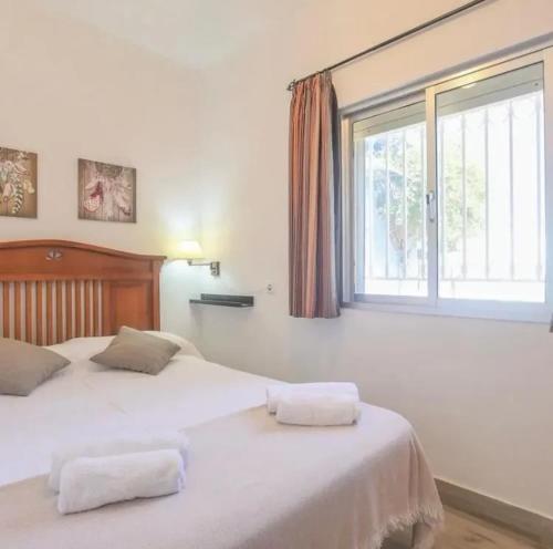 two beds in a bedroom with a window at Spacious Villa in Guillena with Garden and Private Pool in Guillena