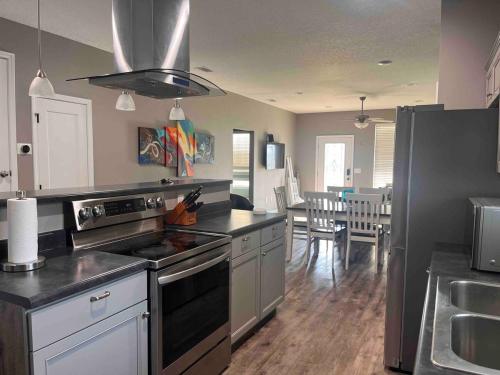 a kitchen with a stove top oven next to a dining room at Gateway To The Gulf in Pensacola