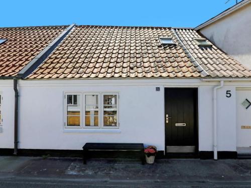 a white house with a bench in front of it at 5 person holiday home in Løkken in Løkken