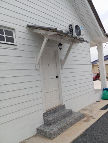 a white house with a white door and a roof at Lu&Lu Rooms & Homestay in Dungun