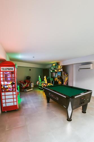 a living room with a pool table and a red booth at Hotel Arena Castillo - New Opening sum 25! in Caleta De Fuste